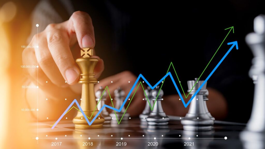 Na obrazku widać szachy i wykres, który na przestrzeni lat idzie w górę