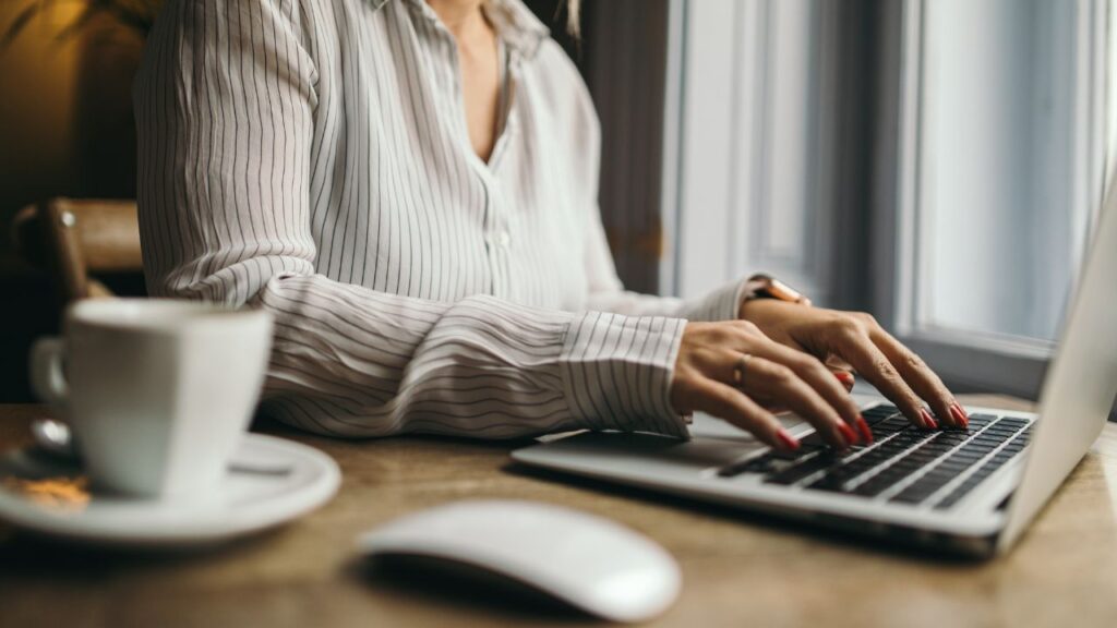 Na obrazku widzimy kobietę, która pracuje na laptopie