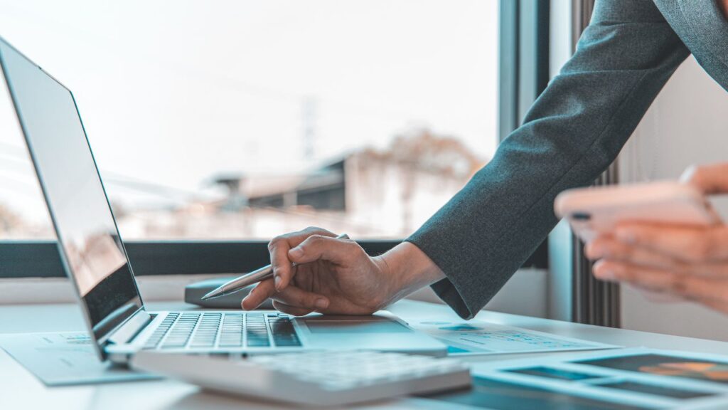 Obrazek przedstawia mężczyznę, który szuka cos w laptopie