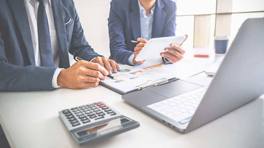 Obrazek przedstawia dwie osoby pracujące nad wykresami